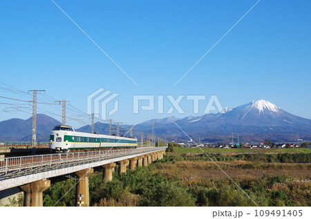 冠雪の大山を背景に日野川の長い鉄道橋梁を駆け抜ける復刻版みどりやくも色の381系特急やくも号 109491405