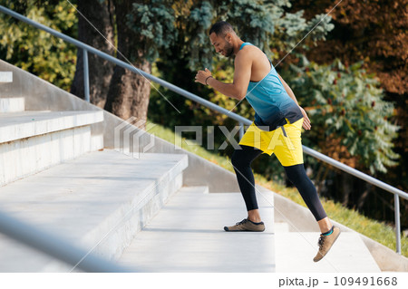 Dark-skinned sportsman running on the stairs during workout 109491668