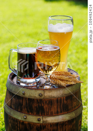 Variety of beer glasses on rustic wooden barrel 109492414