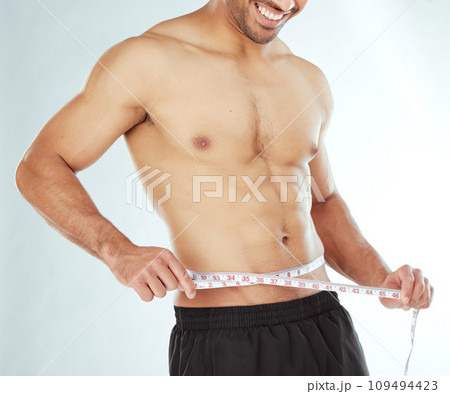 Measuring tape, stomach and fitness man in studio with weight loss, progress or bmi control on white background. Body, wellness and male model with waist measurement for diet, detox or sixpack check Measuring tape, stomach and fitness man in studio with weight loss, progress or bmi control on white background. Body, wellness and male model with waist measurement for diet, detox or sixpack check 109494423