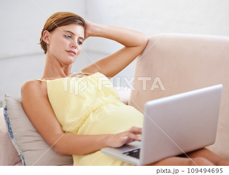 Thinking, pregnant and woman on laptop in house living room for childcare website, information and reading. Vision, ideas and relax person on home sofa with technology, research and pregnancy blog 109494695