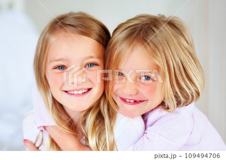 Portrait, sisters and hug indoors with love for relax wellness, happiness and sibling support in home. Children, girls and smile face for fun morning in embrace, family and bonding for care in house Portrait, sisters and hug indoors with love for relax wellness, happiness and sibling support in home. Children, girls and smile face for fun morning in embrace, family and bonding for care in house 109494706