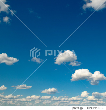 White fluffy clouds and sun on dark blue sky. White fluffy clouds and sun on dark blue sky. 109495005
