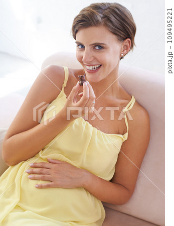 Pregnant woman, eating chocolate and happy in home, alone and enjoying delicious pregnancy craving. Good mood, comfort food and candy dessert for maternity, snack and sweet tooth satisfaction Pregnant woman, eating chocolate and happy in home, alone and enjoying delicious pregnancy craving. Good mood, comfort food and candy dessert for maternity, snack and sweet tooth satisfaction 109495221