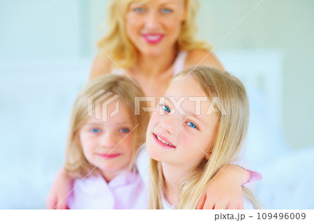 Smile, portrait and mother with children on bed for bonding, relaxing and spending time together. Happy, love and young mom chilling and resting with girl kids from Australia in bedroom of house. 109496009