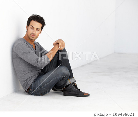 Handsome, fashion and young man by a white wall with casual, cool and trendy outfit. Attractive, confidence and serious male model from Canada sitting on floor with edgy style for aesthetic. Handsome, fashion and young man by a white wall with casual, cool and trendy outfit. Attractive, confidence and serious male model from Canada sitting on floor with edgy style for aesthetic. 109496021