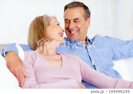 Senior, couple and face or laughing on sofa with support, relationship and bonding in retirement home. Elderly, man and woman with smile on couch in living room with relax, care and love in house Senior, couple and face or laughing on sofa with support, relationship and bonding in retirement home. Elderly, man and woman with smile on couch in living room with relax, care and love in house 109496299