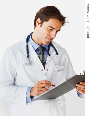 Man, doctor and writing on clipboard for prescription, appointment or checklist against a white studio background. Male person, surgeon or medical professional smile with notes or life insurance 109496883