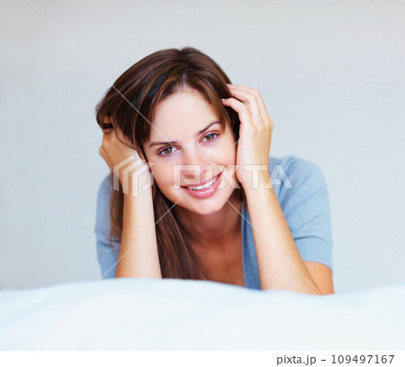 Woman, portrait and relax in bed for happy weekend rest, lazy holiday nap or calm peace. Female person, face and smile for wellness cozy or comfort on duvet for dream vacation, morning in apartment 109497167