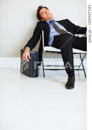 Business man, sleeping and case in lobby, chair and fatigue from travel, overworked or burnout in suit. Entrepreneur, briefcase and tired with rest, exhausted or luggage for corporate job with stress 109497291