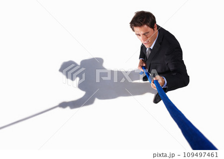 Businessman, conflict and tug of war by white background, career challenge and workplace competition. Young person, mental health and professional worker with rope, top view and job stress in studio Businessman, conflict and tug of war by white background, career challenge and workplace competition. Young person, mental health and professional worker with rope, top view and job stress in studio 109497461