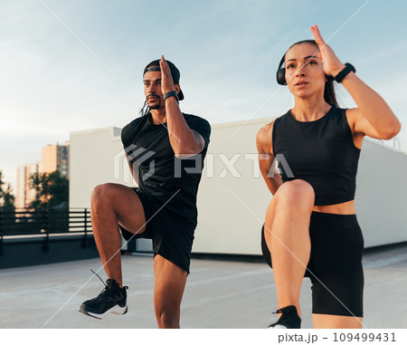 Two athletes in black sportswear practicing together on the roof Two athletes in black sportswear practicing together on the roof 109499431