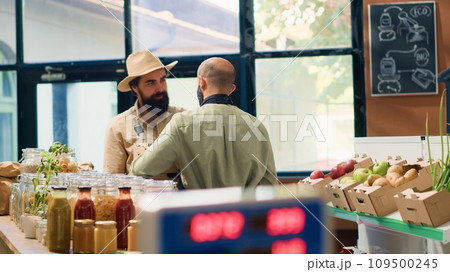 Local farmer delivers products to vendor in zero waste bio supermarket, bringing freshly harvested fruits and veggies in crates. Small business owner supplies storekeeper with goods. Handheld shot. Local farmer delivers products to vendor in zero waste bio supermarket, bringing freshly harvested fruits and veggies in crates. Small business owner supplies storekeeper with goods. Handheld shot. 109500245
