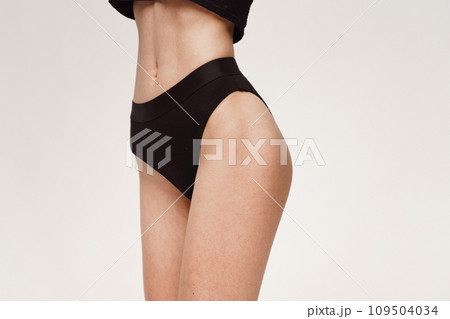 A woman with a beautiful feminine figure in black lingerie with overweight, cellulite and stretch marks. A woman with a beautiful feminine figure in black lingerie with overweight, cellulite and stretch marks. 109504034
