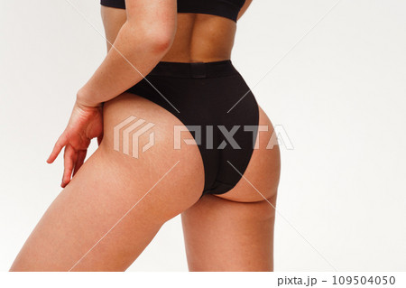 A woman with a beautiful feminine figure in black lingerie with overweight, cellulite and stretch marks. A woman with a beautiful feminine figure in black lingerie with overweight, cellulite and stretch marks. 109504050