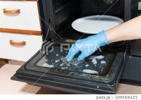 金属たわしでオーブンレンジの掃除を男性の手 109504125