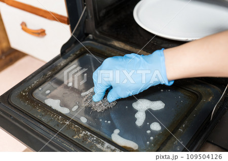 金属たわしでオーブンレンジの掃除を男性の手 109504126