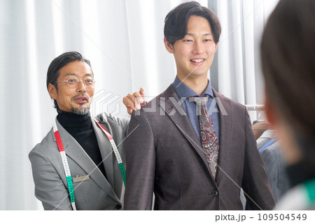 鏡の前でお客と笑顔で会話をするテーラー 鏡の前でお客と笑顔で会話をするテーラー 109504549