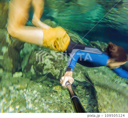 Man immersed in the enchanting beauty of a Mexican cenote, surrounded by crystal-clear waters and captivating natural formations Man immersed in the enchanting beauty of a Mexican cenote, surrounded by crystal-clear waters and captivating natural formations 109505124