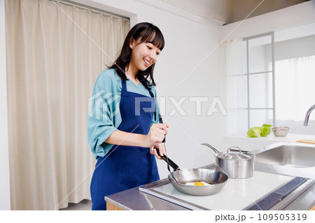 キッチンで卵を焼く女性 109505319