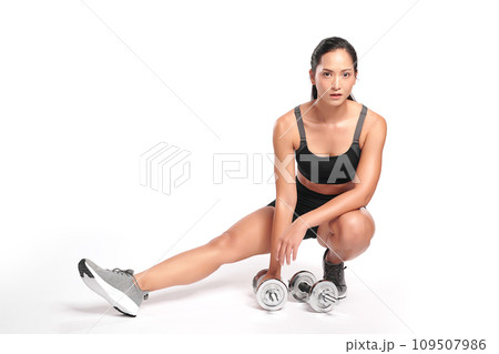an asian woman is working out with dumbbells wearing the sport exercise suit with white background, 109507986