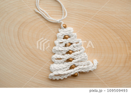 Knitted Christmas Tree as a Gift. Cool Toy Tree Made of Threads on a Wooden Pattern. Miniature Decoration. Handmade Nordic Holiday Decor. Scandinavian Style Design. DIY. Minimal Ornament. Zero Waste 109509493