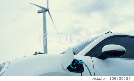 Electric car recharging energy from charging station in wind turbine farm.Peruse 109509587