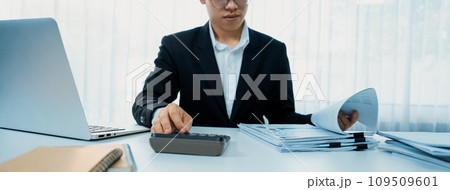 Corporate accountant use calculator to calculate financial report. Shrewd Corporate accountant use calculator to calculate financial report. Shrewd 109509601
