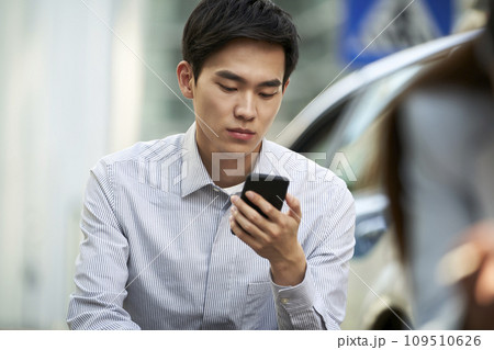 young asian business man using cellphone outdoors 109510626