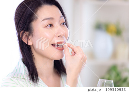 ビューティーイメージ　サプリメントを飲むミドル女性 109510938