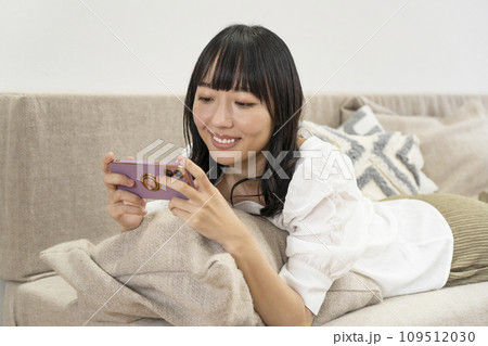 自宅でリラックスしてスマホを操作する女性 自宅でリラックスしてスマホを操作する女性 109512030