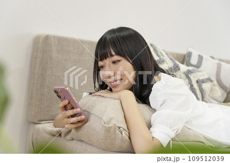 自宅でリラックスしてスマホを操作する女性 自宅でリラックスしてスマホを操作する女性 109512039