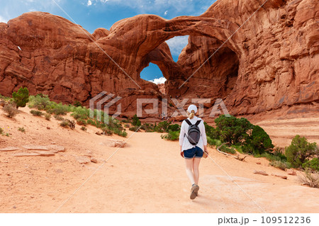 Woman Hiking to Double Arch in Utah National Park 109512236