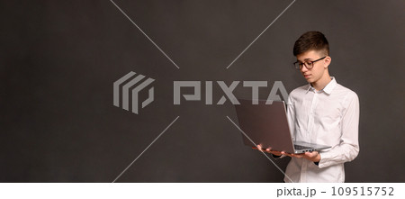 a boy with a laptop on a gray background. concept 109515752