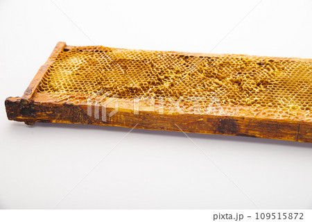 Honeycomb with honey drop on white background 109515872