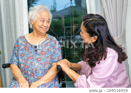 Caregiver help Asian senior woman on wheelchair with love at home. 109516459