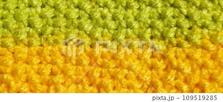 Handmade knitted fabric green and yellow wool background texture Handmade knitted fabric green and yellow wool background texture 109519285