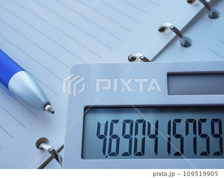 テーブルに置かれた手帳と電卓 109519905