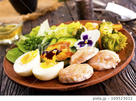 Fried salmon cutlets on a plate with vegetables and boiled eggs Fried salmon cutlets on a plate with vegetables and boiled eggs 109523012