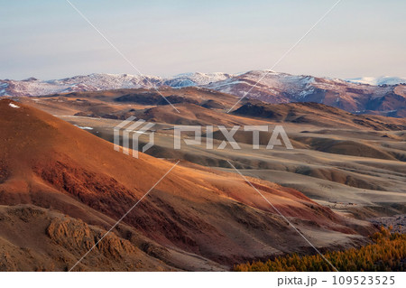 Unusual texture of the mountains, there is snow in the veins of the rock, the surface of the plateau is heated by the sun. Amazing red mountain plateau at sunset is lightly sprinkled with snow. Unusual texture of the mountains, there is snow in the veins of the rock, the surface of the plateau is heated by the sun. Amazing red mountain plateau at sunset is lightly sprinkled with snow. 109523525