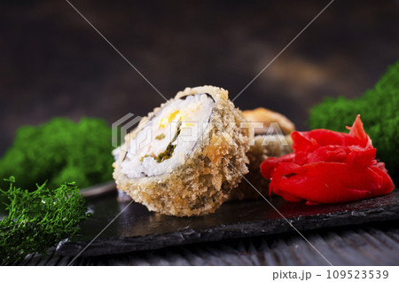 Sushi roll with salmon, smoked eel, avocado, cream cheese on black background. Sushi menu. Japanese food. 109523539