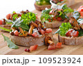 Delicious canapes with rucola-tomato-salad and fried chanterelles 109523924