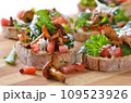 Delicious canapes with rucola-tomato-salad and fried chanterelles 109523926