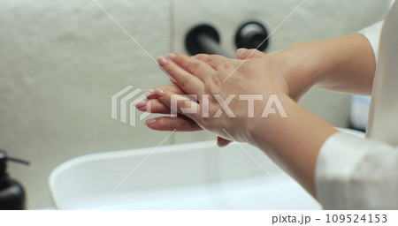 Woman in bathrobe applying moisturizing pampering cream on skin at bathroom. Beauty cosmetics at home. 109524153