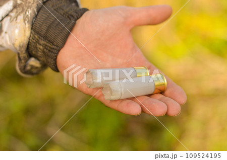 A close-up of a hunter's hand with spent cartridges. The concept of hunting. A close-up of a hunter's hand with spent cartridges. The concept of hunting. 109524195
