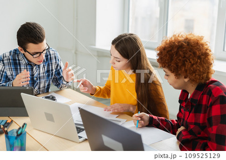 Teamwork brainstorm. Diverse colleagues working together discuss financial statistics. Group of happy young modern people sitting in creative office discussing business. Young professional team Teamwork brainstorm. Diverse colleagues working together discuss financial statistics. Group of happy young modern people sitting in creative office discussing business. Young professional team 109525129