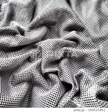 Synthetic fabric with holes laid in waves. Beautiful drape. Fabric for curtains, interior design, and decor. Wrinkled gray fabric. Synthetic fabric with holes laid in waves. Beautiful drape. Fabric for curtains, interior design, and decor. Wrinkled gray fabric. 109525861