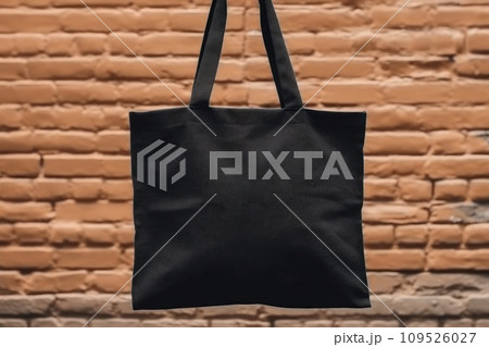 AI-generated content. Hand holding black cotton tote bag mockup on a wall background 109526027