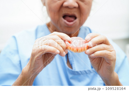 Doctor holding teeth denture in hand for dentist studying about dentistry. 109528164