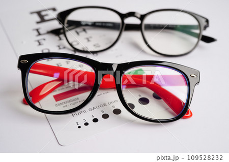 Glasses on eye exam chart to test eyesight accuracy of reading. Glasses on eye exam chart to test eyesight accuracy of reading. 109528232